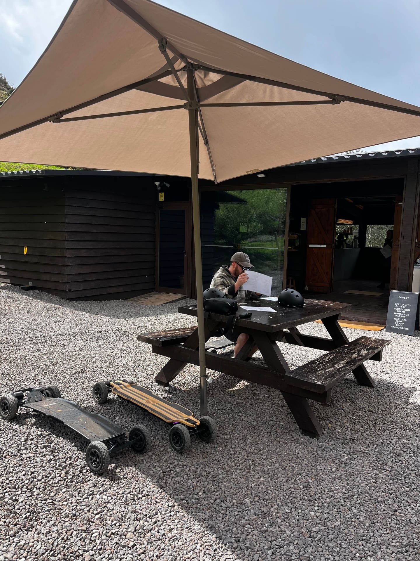 Rider taking a coffee break with electric mountainboards parked at a Madeira forest cafe